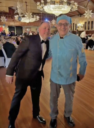 Photo of a man in a suit next to a chef