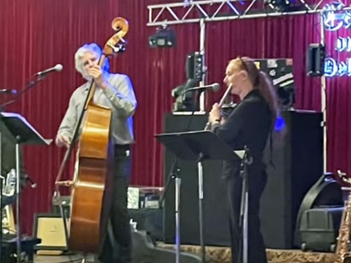 A man plays an upright bass while a woman plays the flute