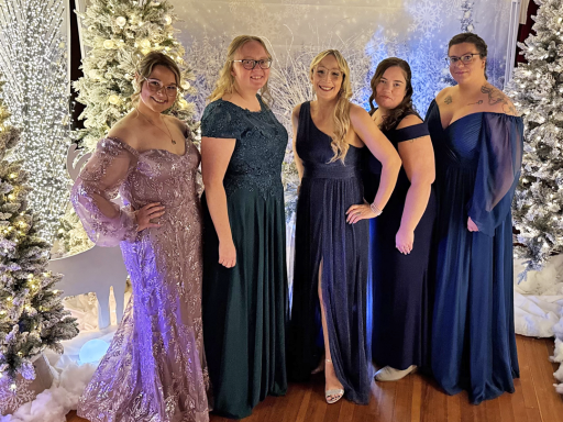 Group photo of five women in gowns amidst a wintery scene