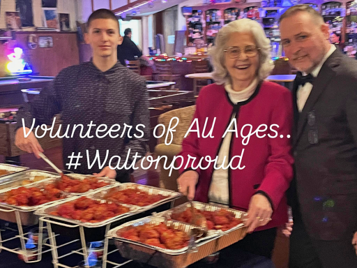 Three people posing for a photo next to buffet station